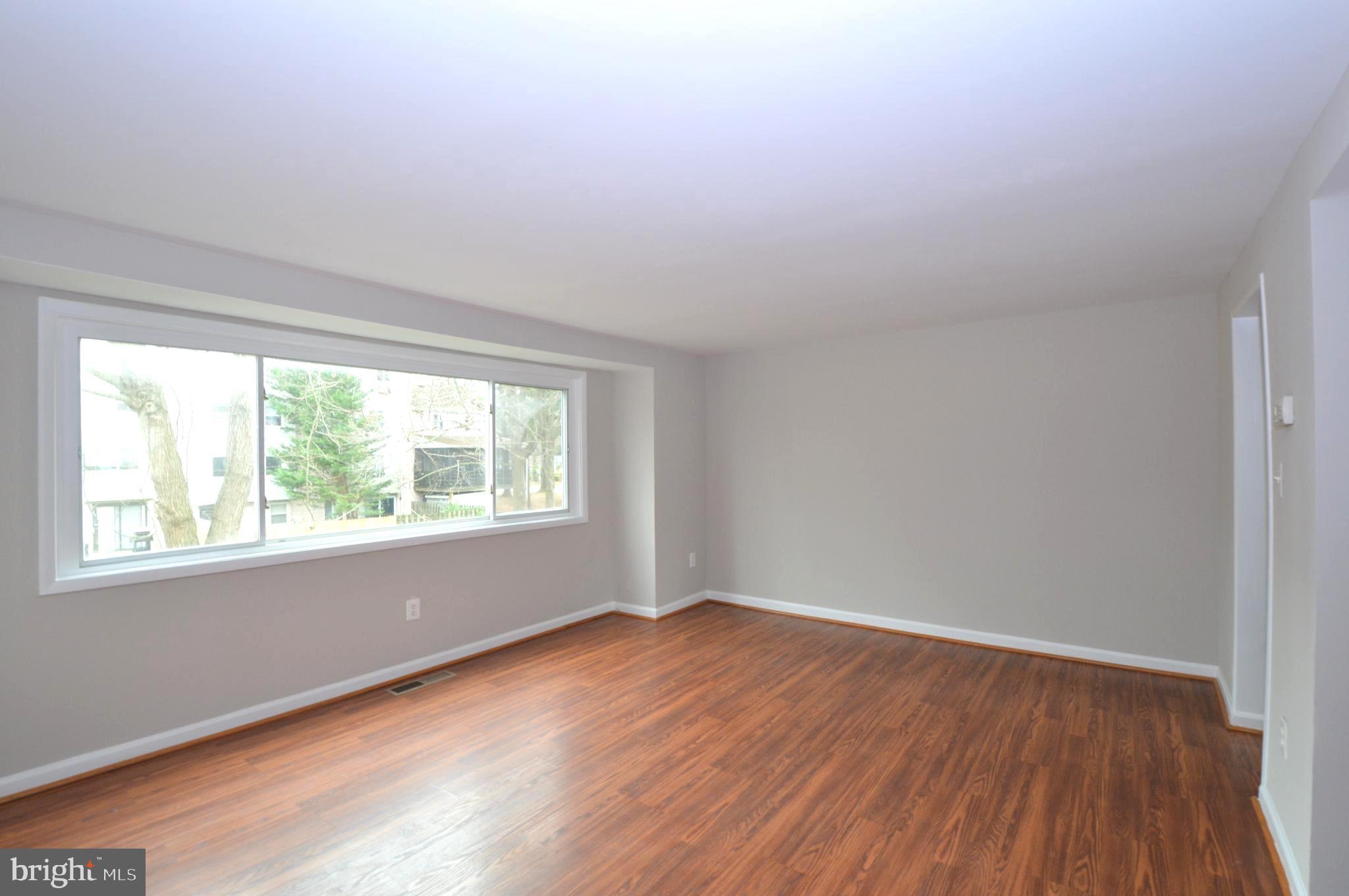 9410 Merryrest Road Columbia, MD 21045 - Photo 5 of 26 an empty room with wooden floor and windows