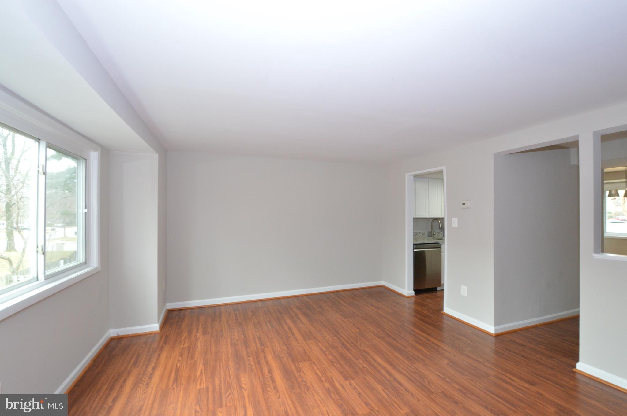 9410 Merryrest Road Columbia, MD 21045 - Photo 7 of 26 an empty room with wooden floor and windows