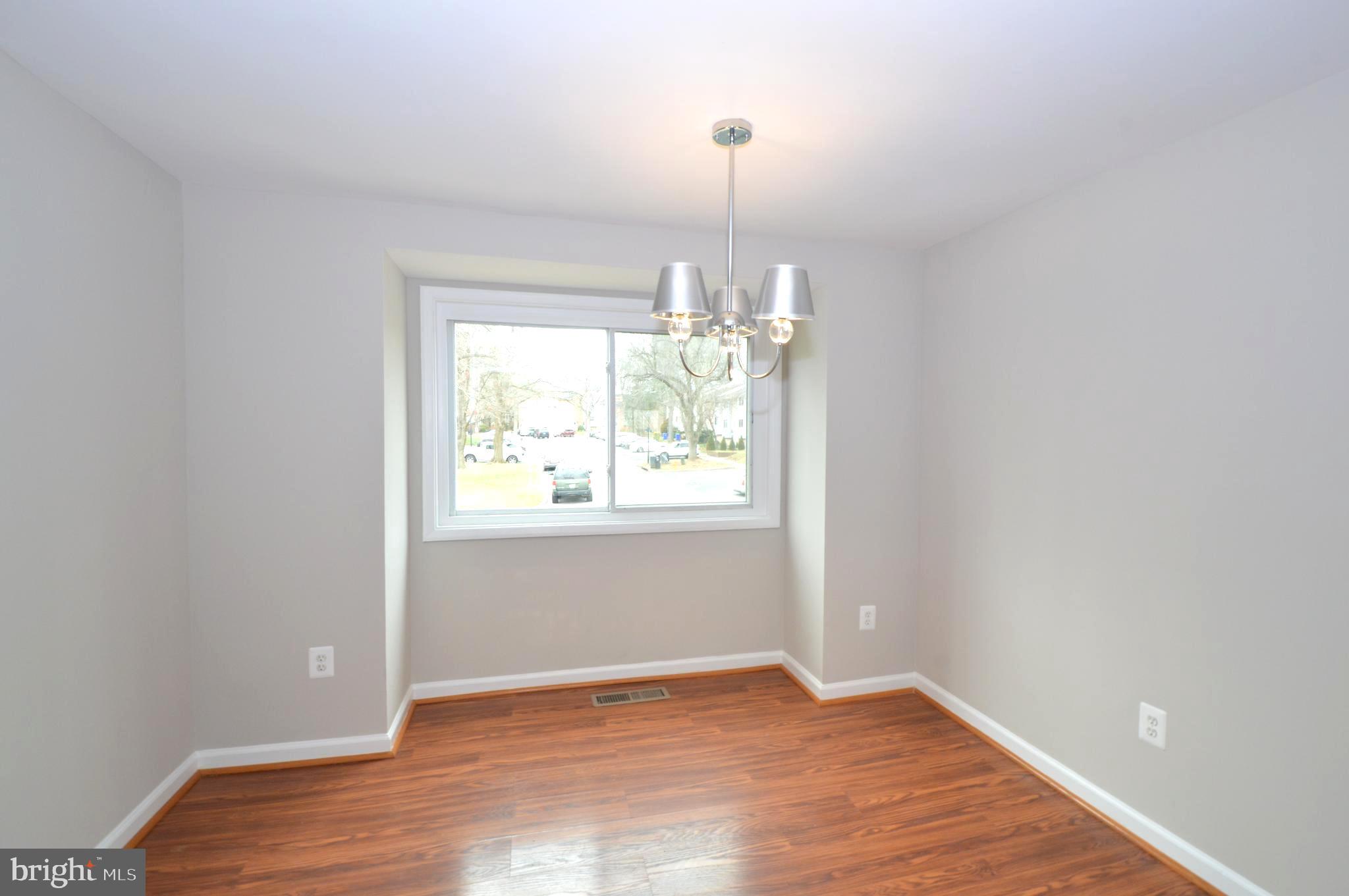 9410 Merryrest Road Columbia, MD 21045 - Photo 9 of 26 an empty room with wooden floor and windows