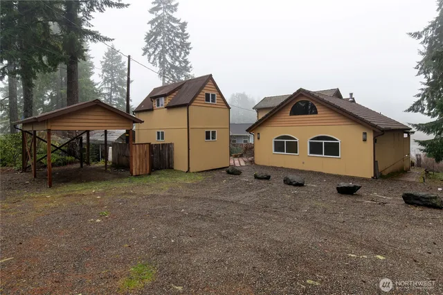 a view of house with backyard and outdoor seating