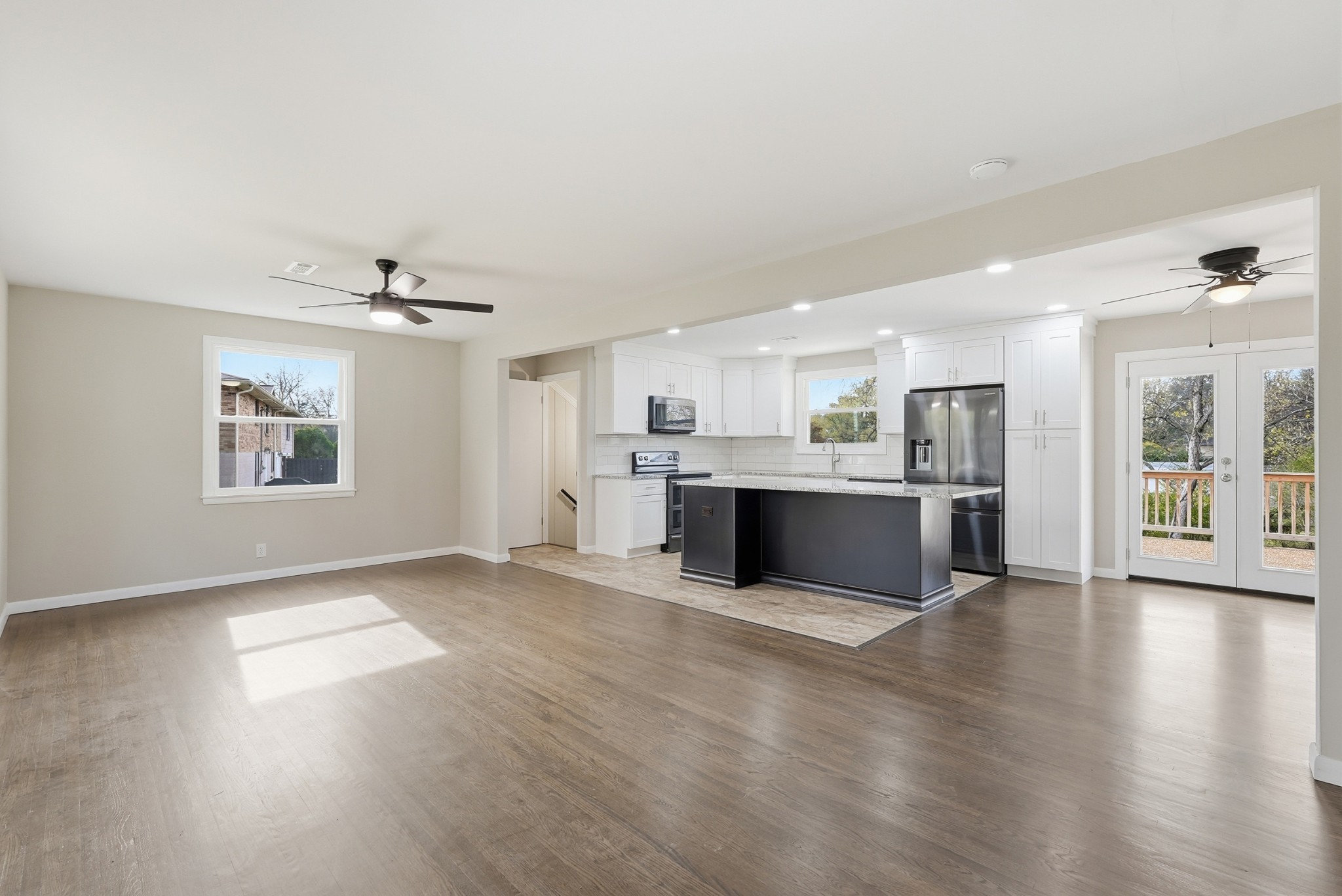 558 Walton Ferry Road Hendersonville, TN 37075 - Photo 6 of 28 a large white kitchen with kitchen island a sink wooden floor and a refrigerator
