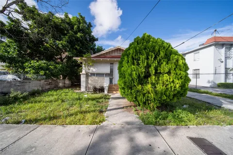 a pathway of a house with a garden