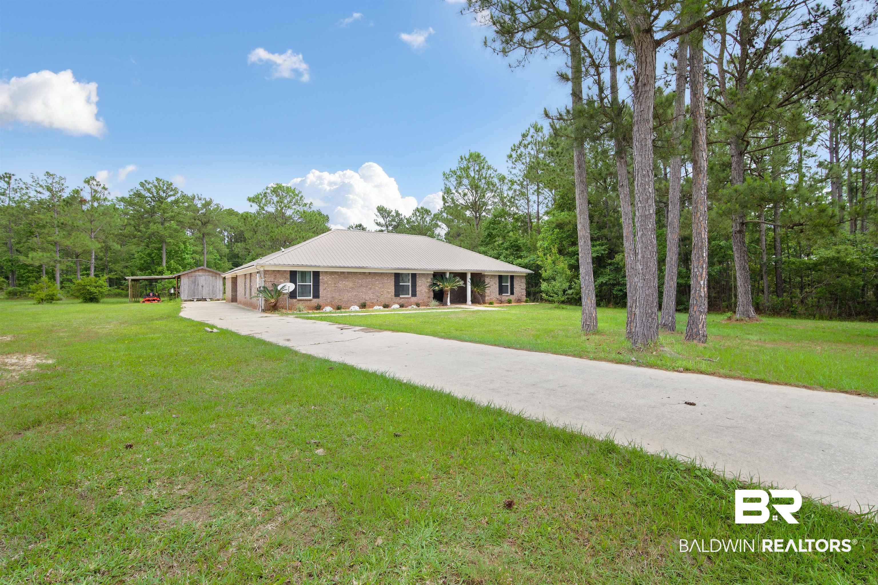 3010 Drag Strip Lane Coden, AL 36523 - Photo 4 of 44 View of front of home featuring a front lawn, metal roof, and driveway