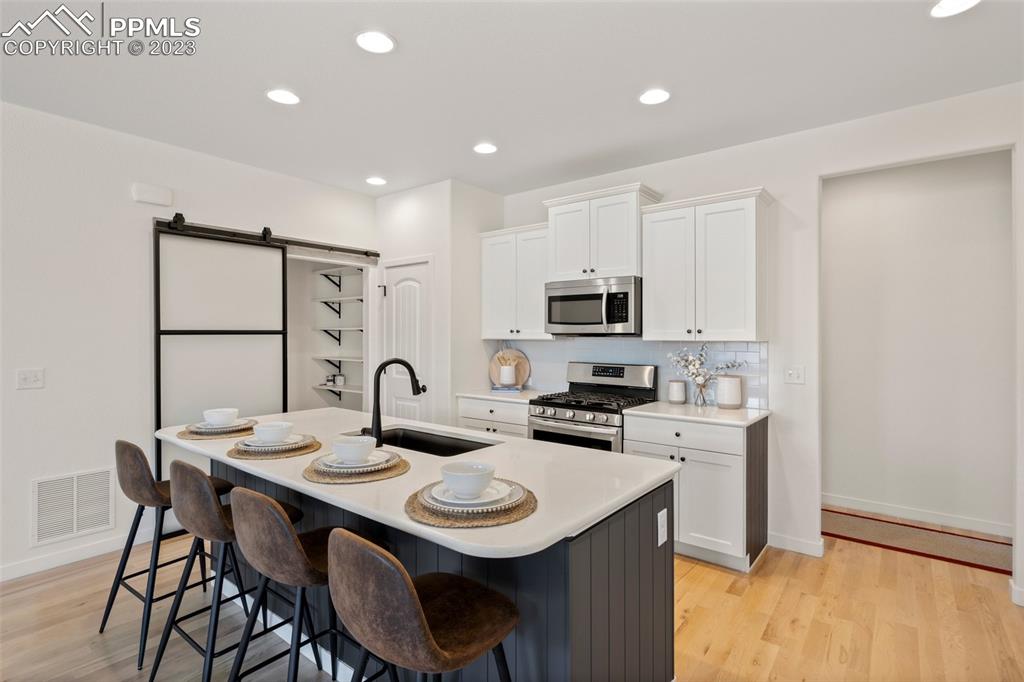 11969 Alydar Loop Colorado Springs, CO 80921 - Photo 11 of 44 a kitchen with a sink a stove a table and chairs