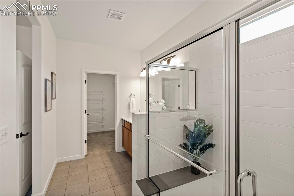 11969 Alydar Loop Colorado Springs, CO 80921 - Photo 16 of 44 a spacious bathroom with a shower and mirror