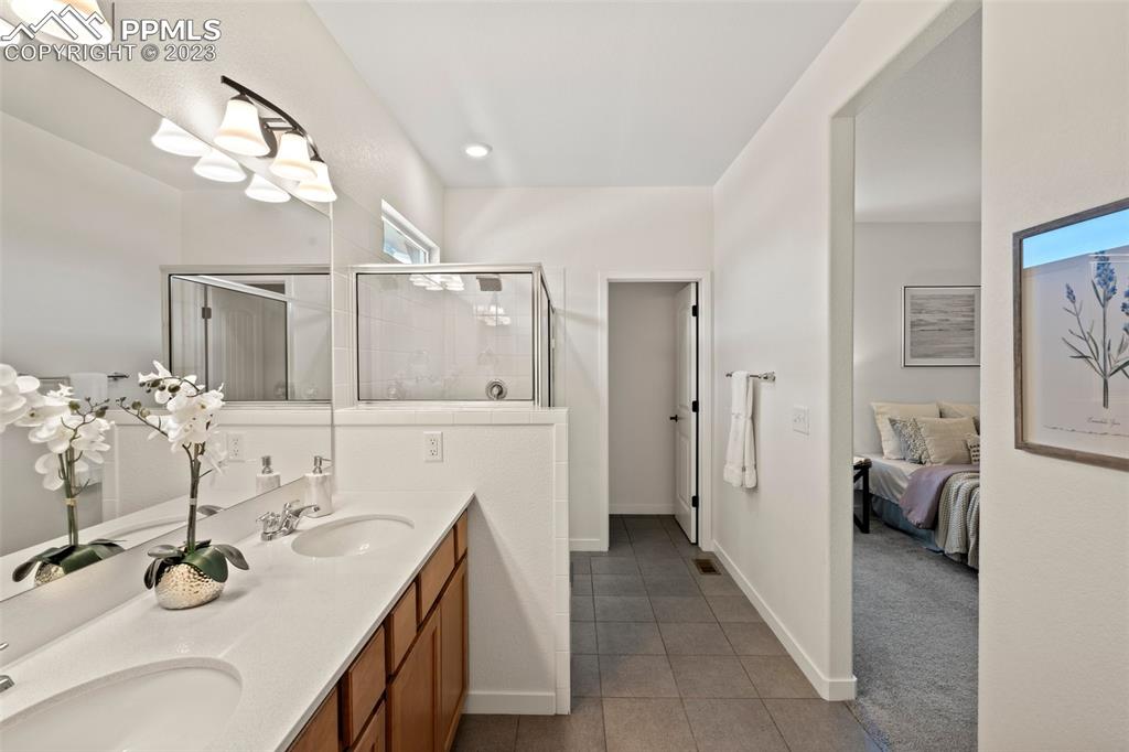 11969 Alydar Loop Colorado Springs, CO 80921 - Photo 17 of 44 a bathroom with a granite countertop sink mirror and shower