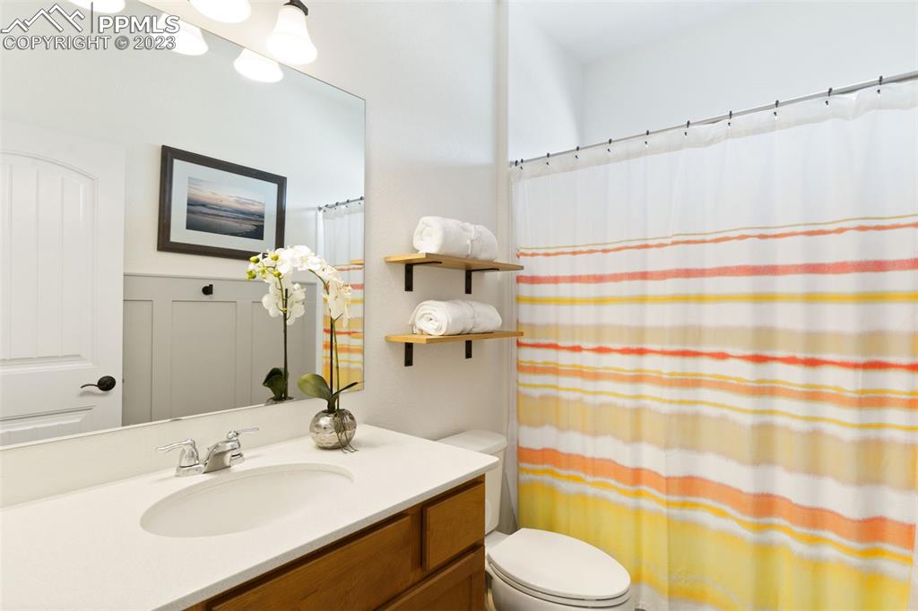11969 Alydar Loop Colorado Springs, CO 80921 - Photo 20 of 44 a bathroom with a sink toilet mirror and shower curtain
