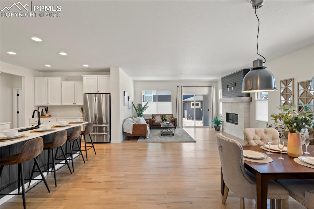 11969 Alydar Loop Colorado Springs, CO 80921 - Photo 6 of 44 a view of a dining room and livingroom with furniture wooden floor a chandelier
