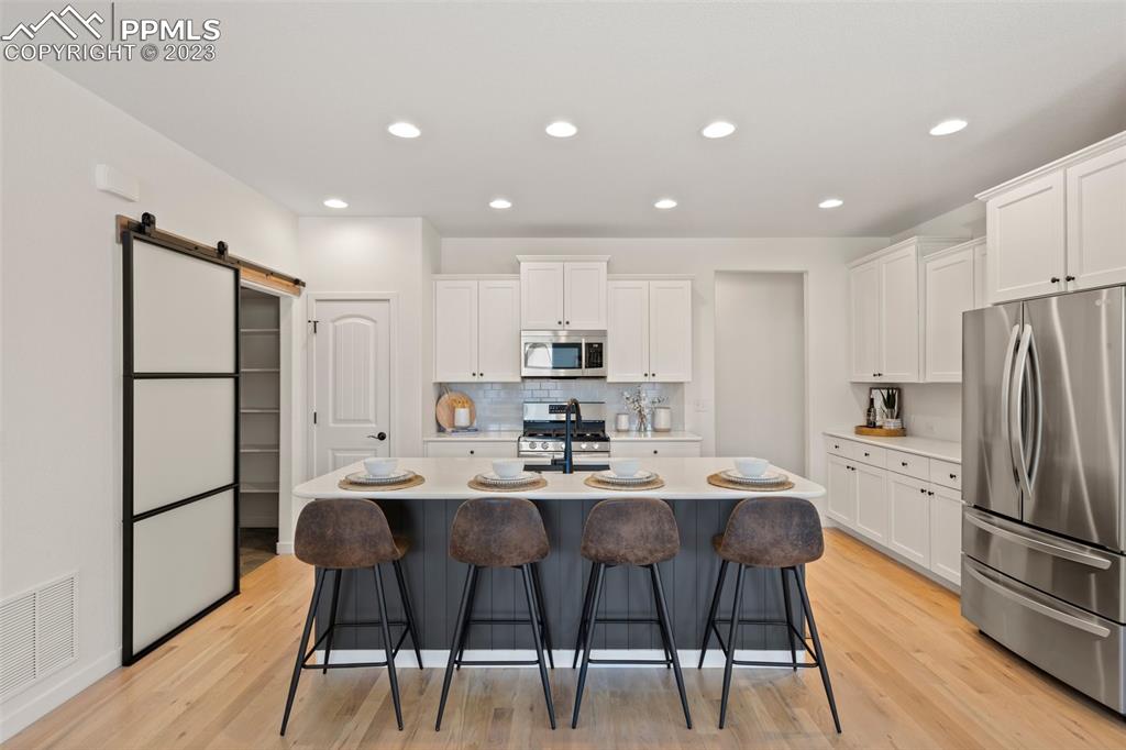 11969 Alydar Loop Colorado Springs, CO 80921 - Photo 10 of 44 a kitchen with a refrigerator a dining table and chairs