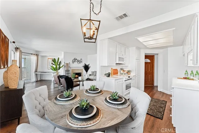 a dining room with furniture a kitchen view and wooden floor