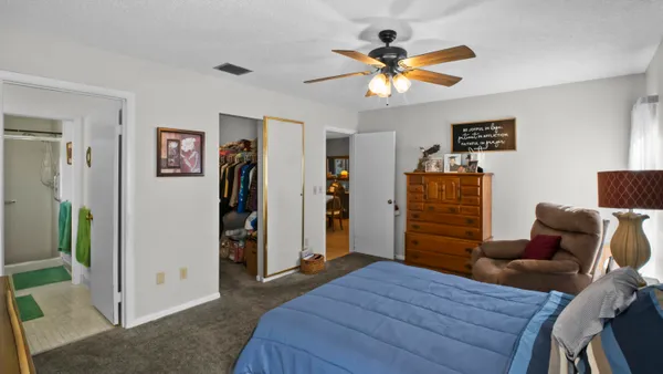 a bedroom with a bed and a ceiling fan