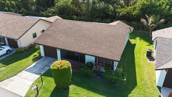 a aerial view of a house with table and chairs under an umbrella