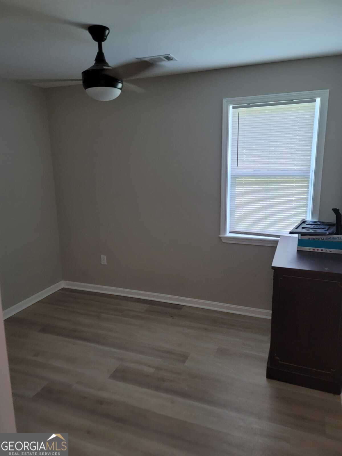 1559 Alma Street Southwest Atlanta, GA 30311 - Photo 3 of 7 a view of an empty room with wooden floor and a window