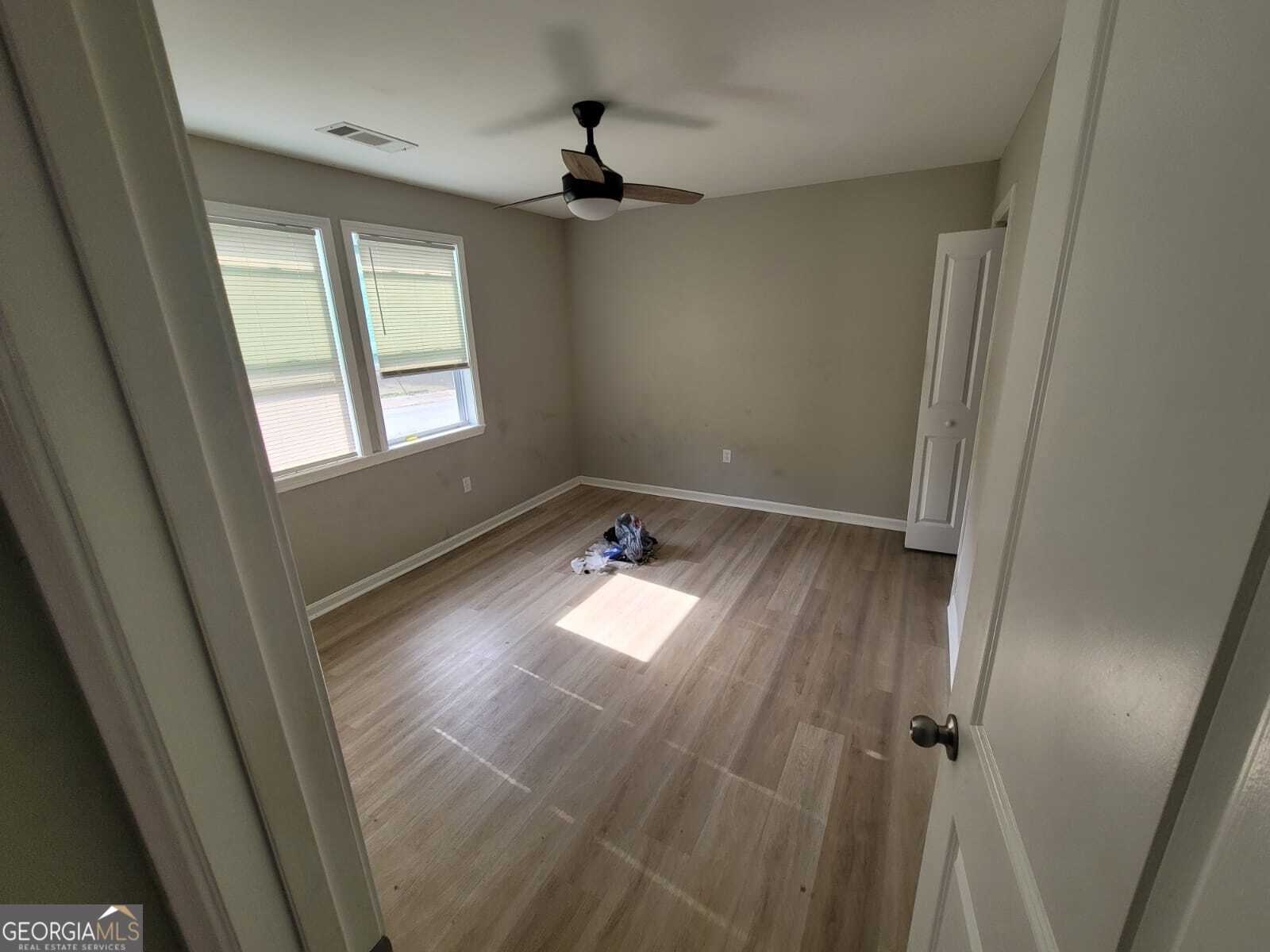 1559 Alma Street Southwest Atlanta, GA 30311 - Photo 5 of 7 wooden floor in an empty room with a window