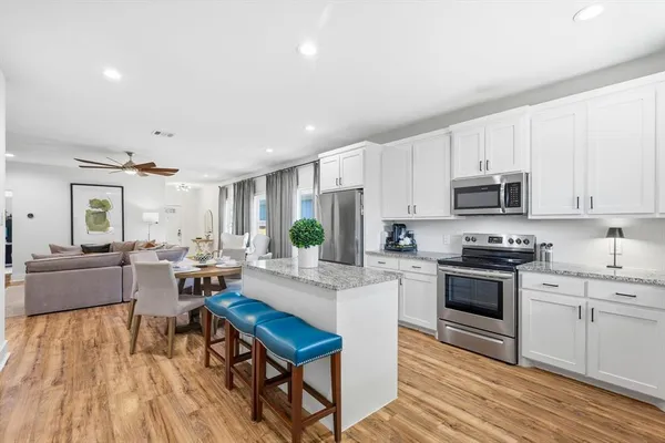 a kitchen with white cabinets and stainless steel appliances