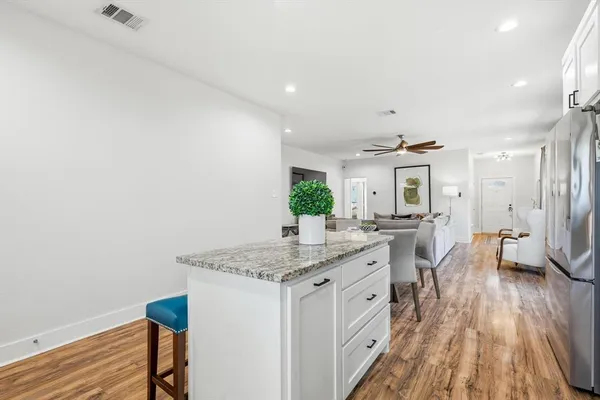 a spacious bathroom with a granite countertop sink a mirror and a toilet