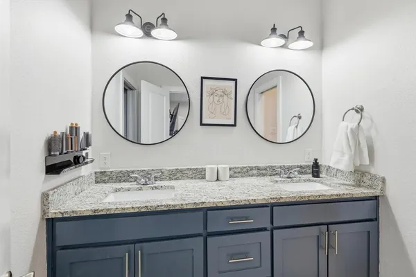 a bathroom with a granite countertop double vanity sinks and a mirror
