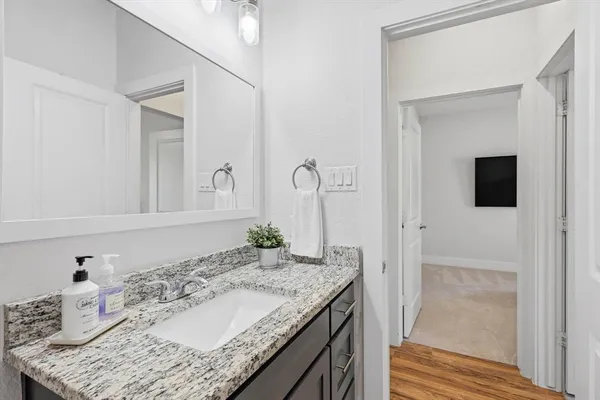 a bathroom with a granite countertop sink and a mirror