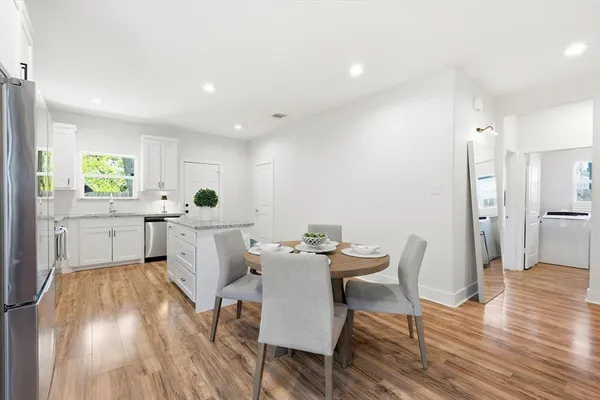 a kitchen with white cabinets and stainless steel appliances