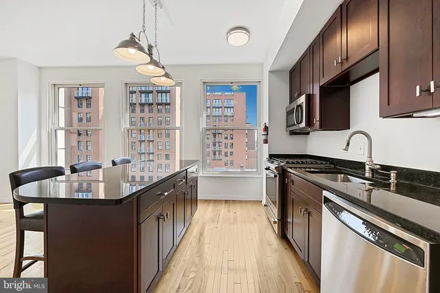 a kitchen with granite countertop a sink stove and cabinets