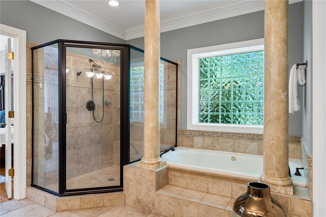 200 Graylyn Drive Anderson, SC 29621 - Photo 20 of 48 Indulge in a primary bathroom featuring a spacious walk-in shower and a built-in soaking tub, framed by classic columns.
