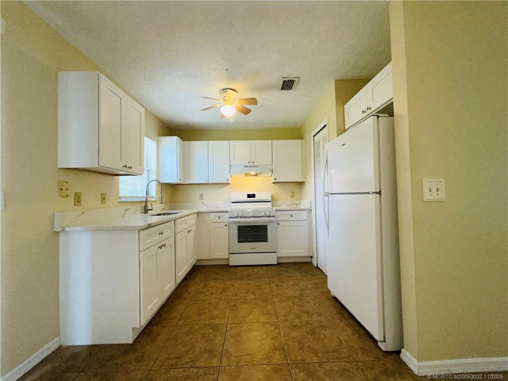 2010 Southwest Beauregard Street Port St. Lucie, FL 34953 - Photo 4 of 10 a kitchen with a refrigerator a sink and dishwasher