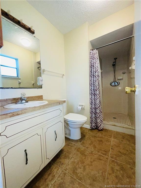 2010 Southwest Beauregard Street Port St. Lucie, FL 34953 - Photo 7 of 10 a bathroom with a granite countertop sink toilet and shower