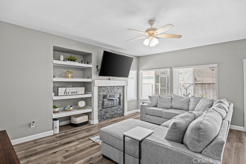 1251 Stepstone Court Hemet, CA 92545 - Photo 11 of 51 a living room with furniture a flat screen tv and a fireplace