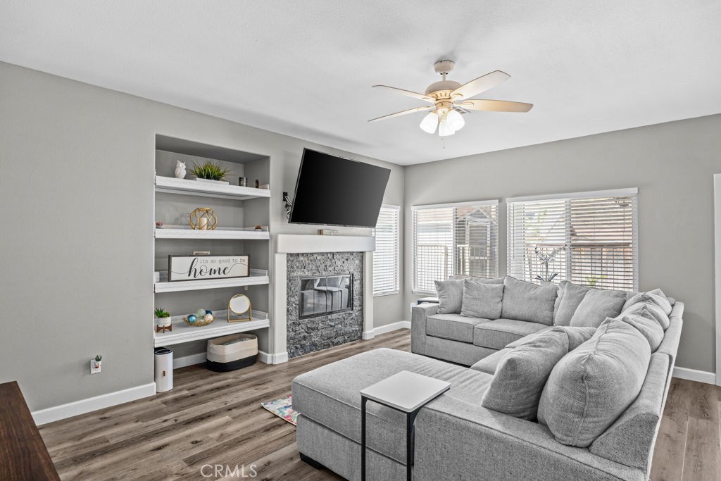 1251 Stepstone Court Hemet, CA 92545 - Photo 13 of 51 a living room with furniture a flat screen tv and a fireplace