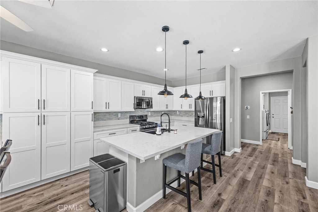 1251 Stepstone Court Hemet, CA 92545 - Photo 7 of 51 a kitchen with a table chairs refrigerator and cabinets