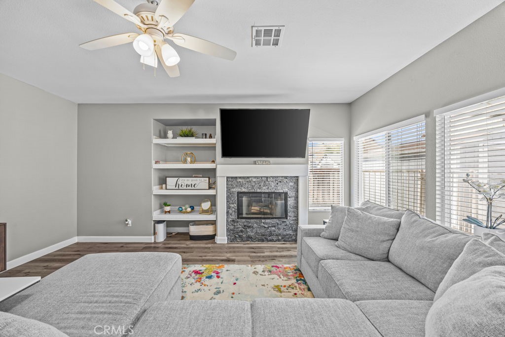 1251 Stepstone Court Hemet, CA 92545 - Photo 10 of 51 a living room with furniture a fireplace and a flat screen tv