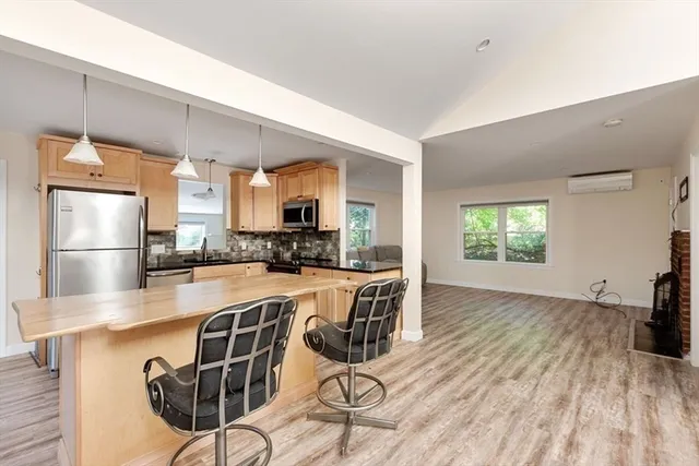 a kitchen with stainless steel appliances granite countertop a refrigerator a stove a sink dishwasher with a dining table and chairs