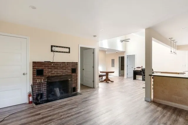 a living room with furniture a fireplace and wooden floor