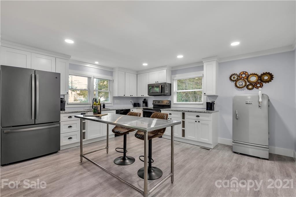 2616 Williams Road Matthews, NC 28105 - Photo 11 of 26 a kitchen with stainless steel appliances kitchen island granite countertop a refrigerator a stove a sink dishwasher and a dining table with wooden floor