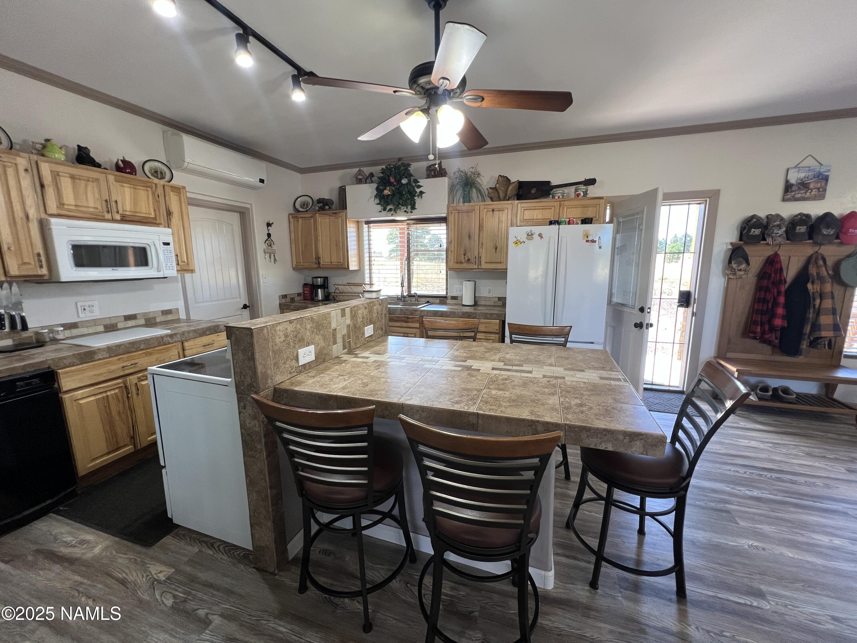 665 Dust Devil Drive Parks, AZ 86005 - Photo 12 of 44 a kitchen with stainless steel appliances granite countertop a stove a sink dishwasher a dining table and chairs with wooden floor