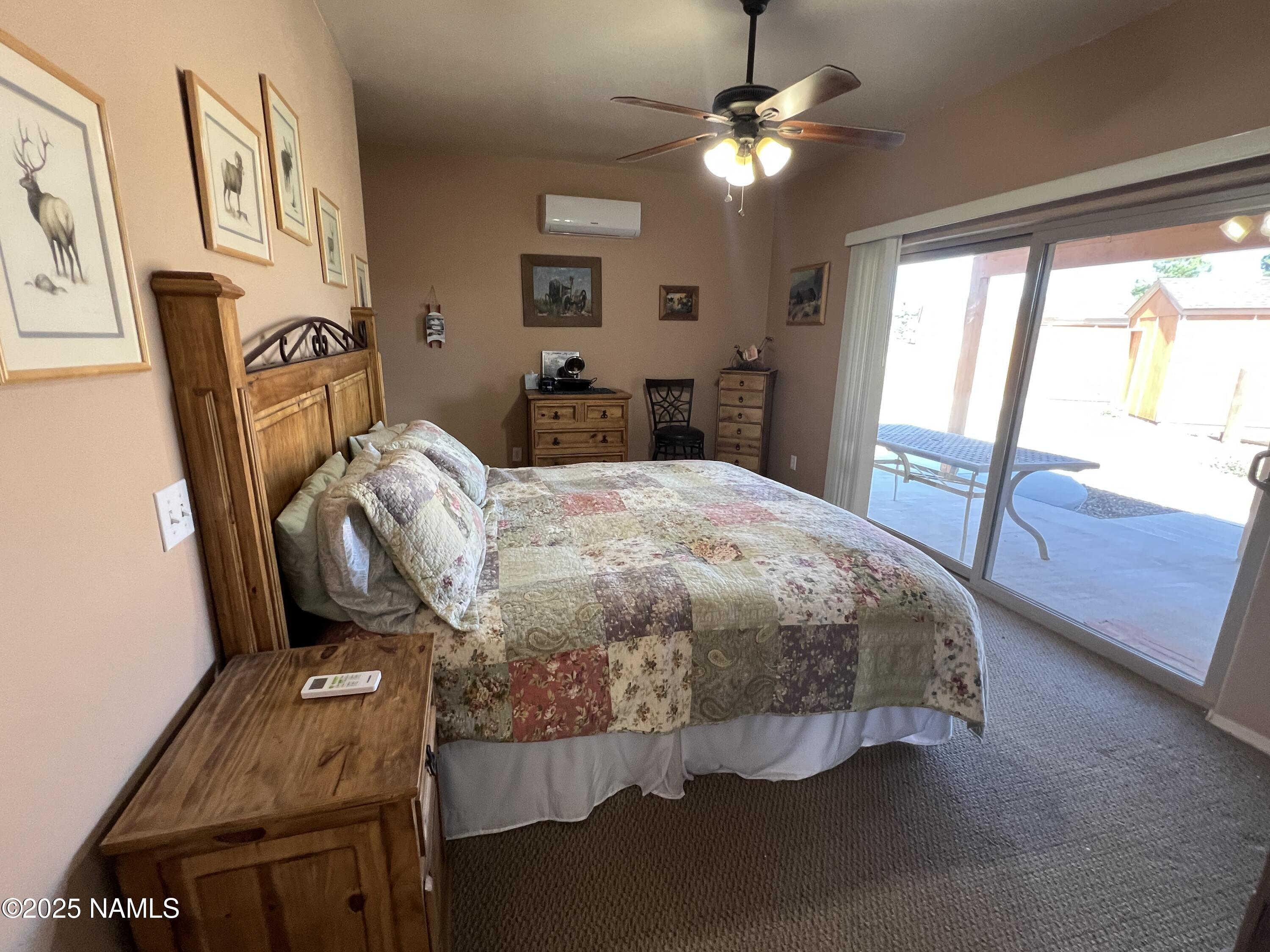 665 Dust Devil Drive Parks, AZ 86005 - Photo 19 of 44 a bedroom with a bed and a chandelier