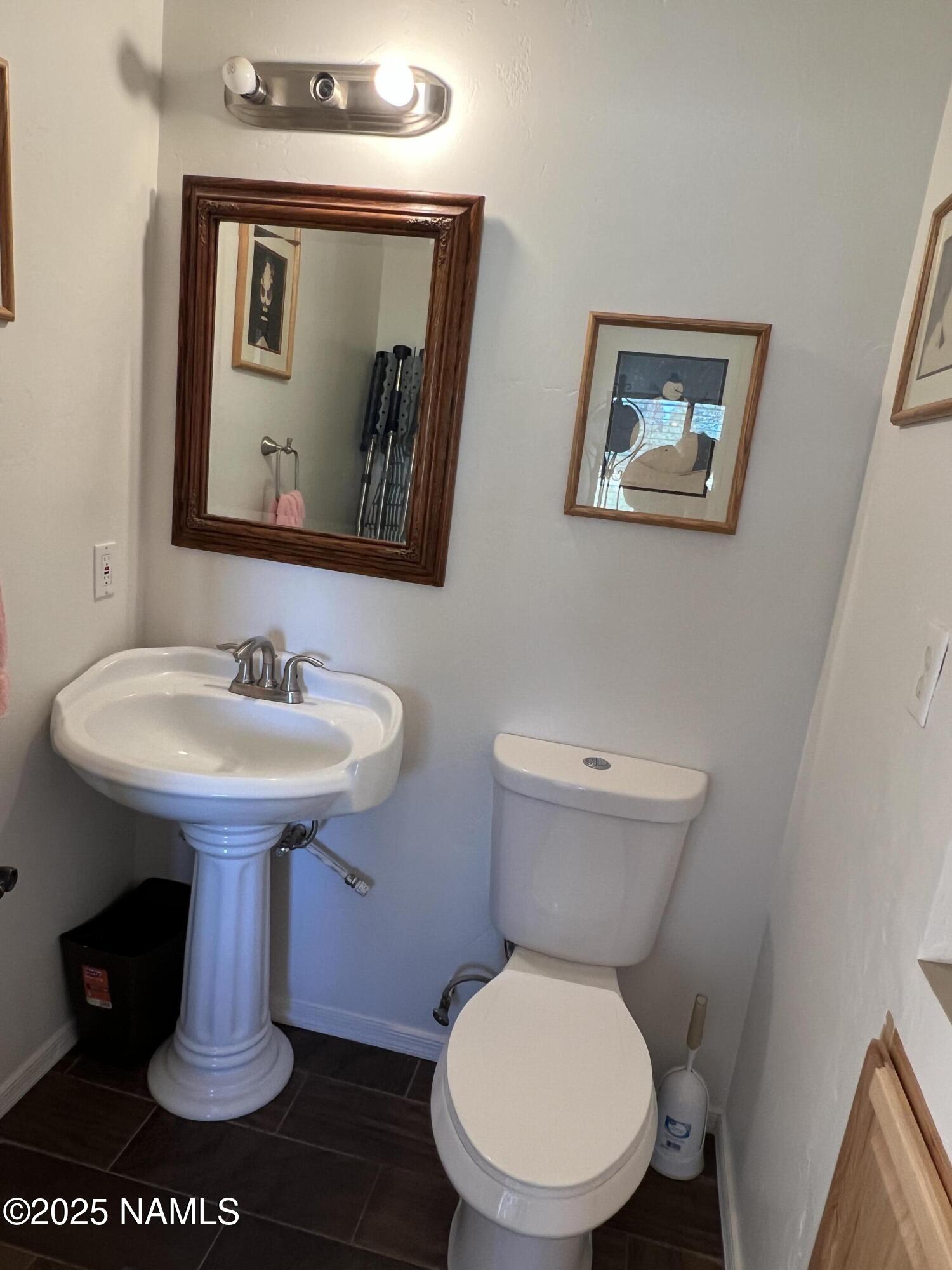 665 Dust Devil Drive Parks, AZ 86005 - Photo 20 of 44 a bathroom with a toilet sink and mirror