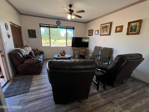 a living room with furniture a window and a flat screen tv