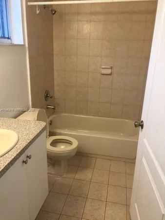 a bathroom with a granite countertop toilet and a sink