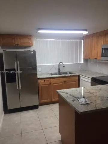 a kitchen with granite countertop a stove microwave and sink
