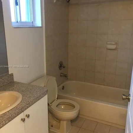 a bathroom with a granite countertop sink a toilet and shower