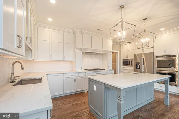 a kitchen with stainless steel appliances a refrigerator stove and cabinets