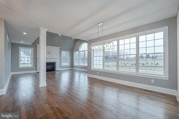 an empty room with wooden floor and a fireplace
