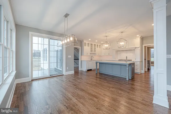 an empty room with wooden floor fireplace and windows