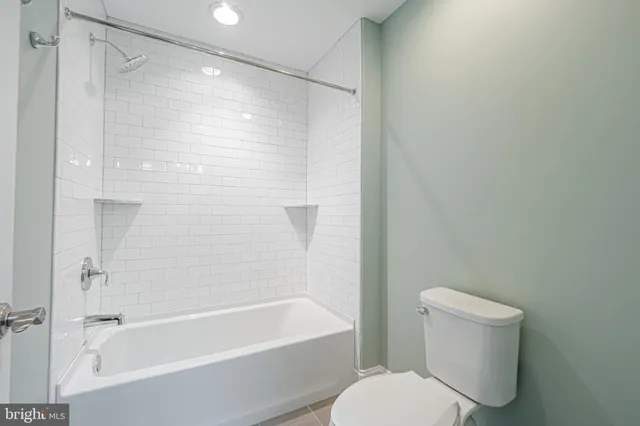 a bathroom with a granite countertop sink a toilet and a window
