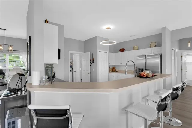 a kitchen with a refrigerator and white cabinets