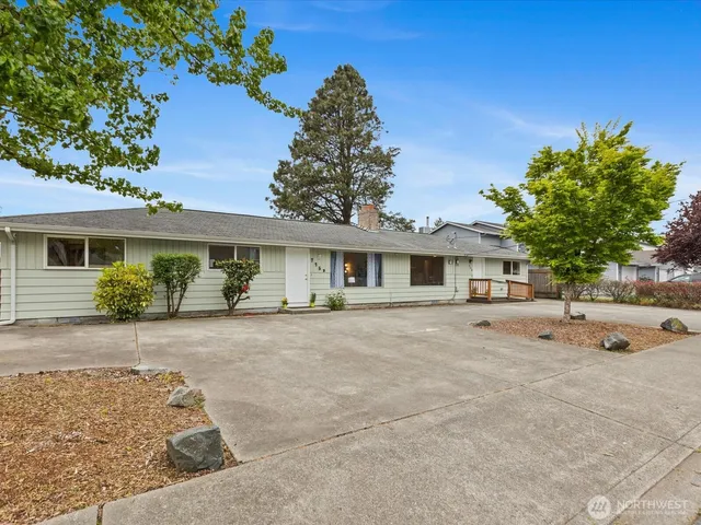 a front view of a house with a garden and trees