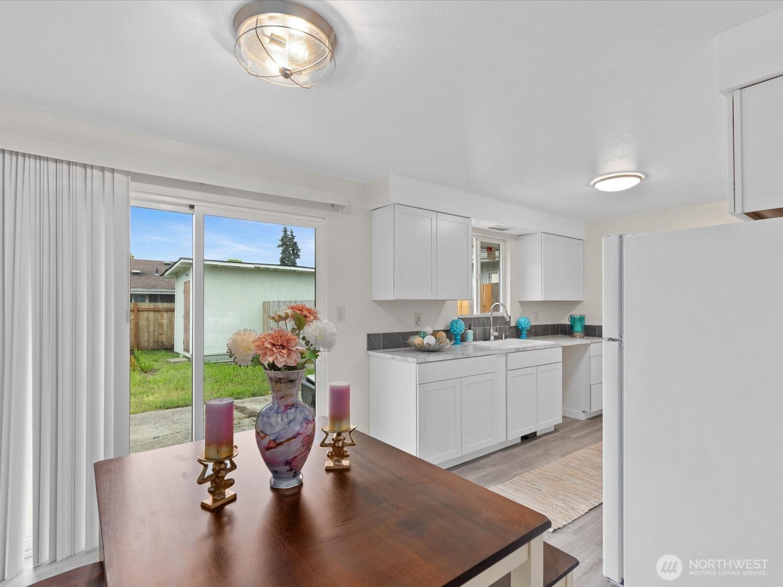 735 F Street Northeast Auburn, WA 98002 - Photo 7 of 31 a kitchen with a table chairs and a refrigerator
