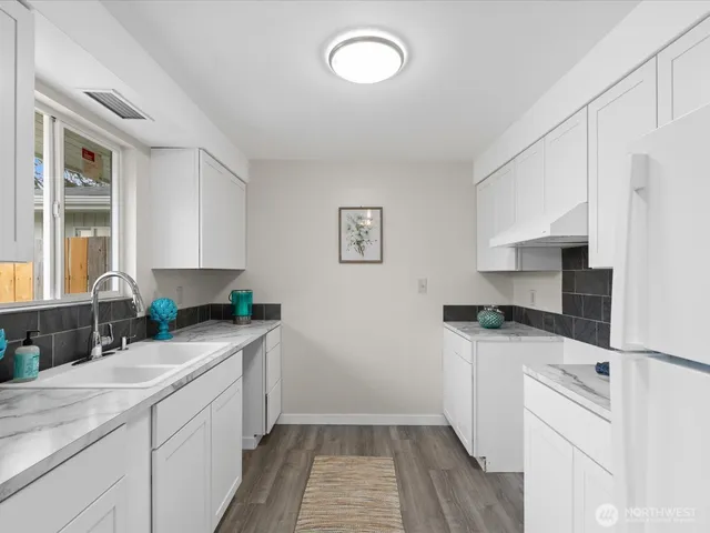a kitchen with a sink a stove and cabinets