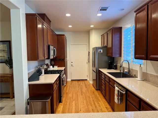a kitchen with kitchen island granite countertop a sink stove and refrigerator